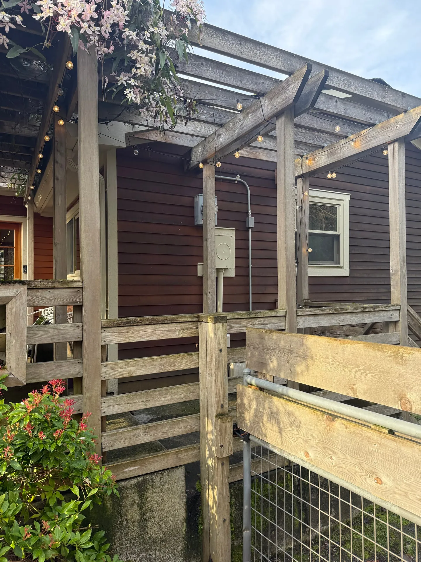 Exterior deck and pergola at a Felida home in Vancouver, WA before the Tesla Wall Connector install, showing the existing meter base and subpanel mounted on the house siding