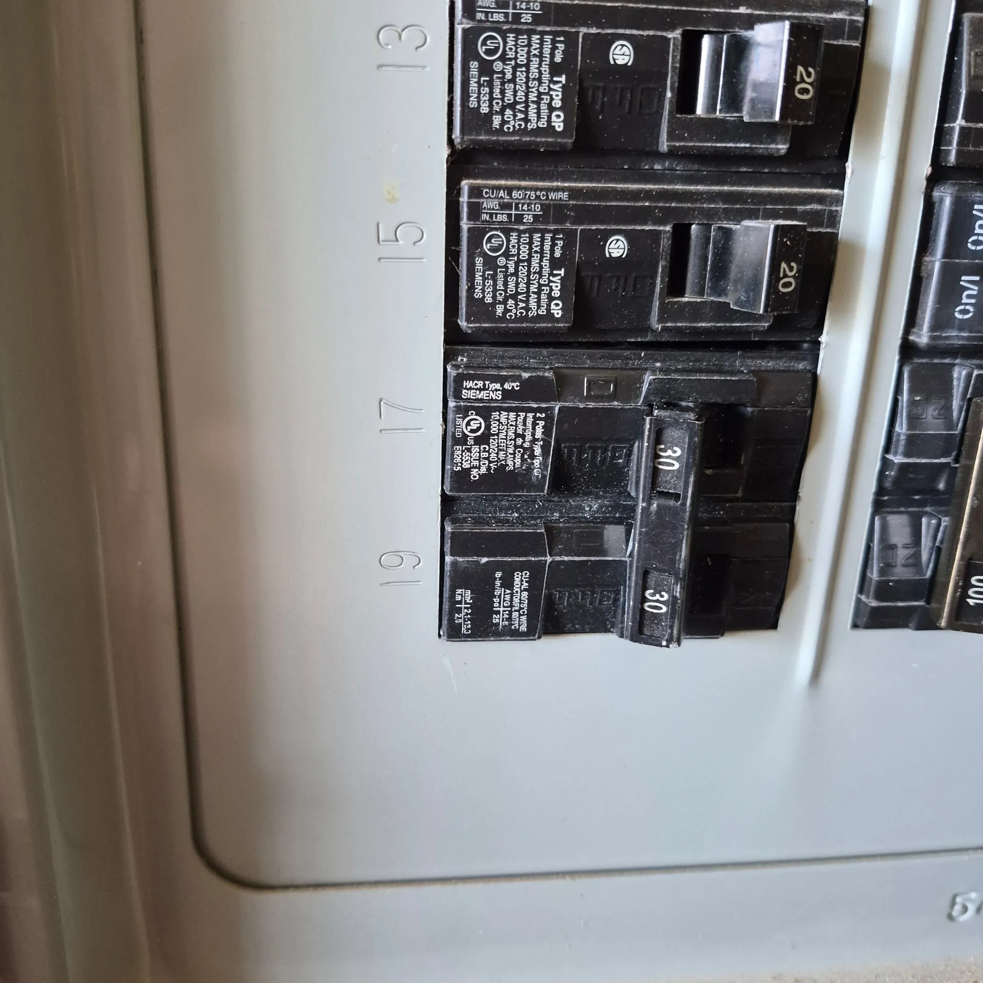 Close-up of a Siemens electrical panel showing the new 2-pole 30-amp breaker landed for the A/C condenser circuit alongside existing 20-amp breakers