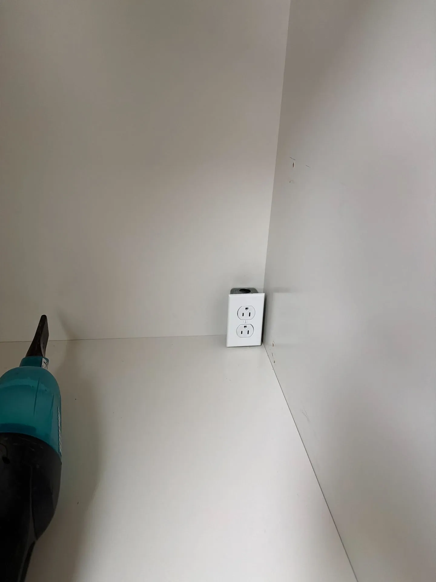 Standard duplex outlet box protruding two inches proud of finished drywall in a Camas WA remodel, before Newman Electric recessed the box back into the wall cavity so built-in cabinetry could sit flat against the wall