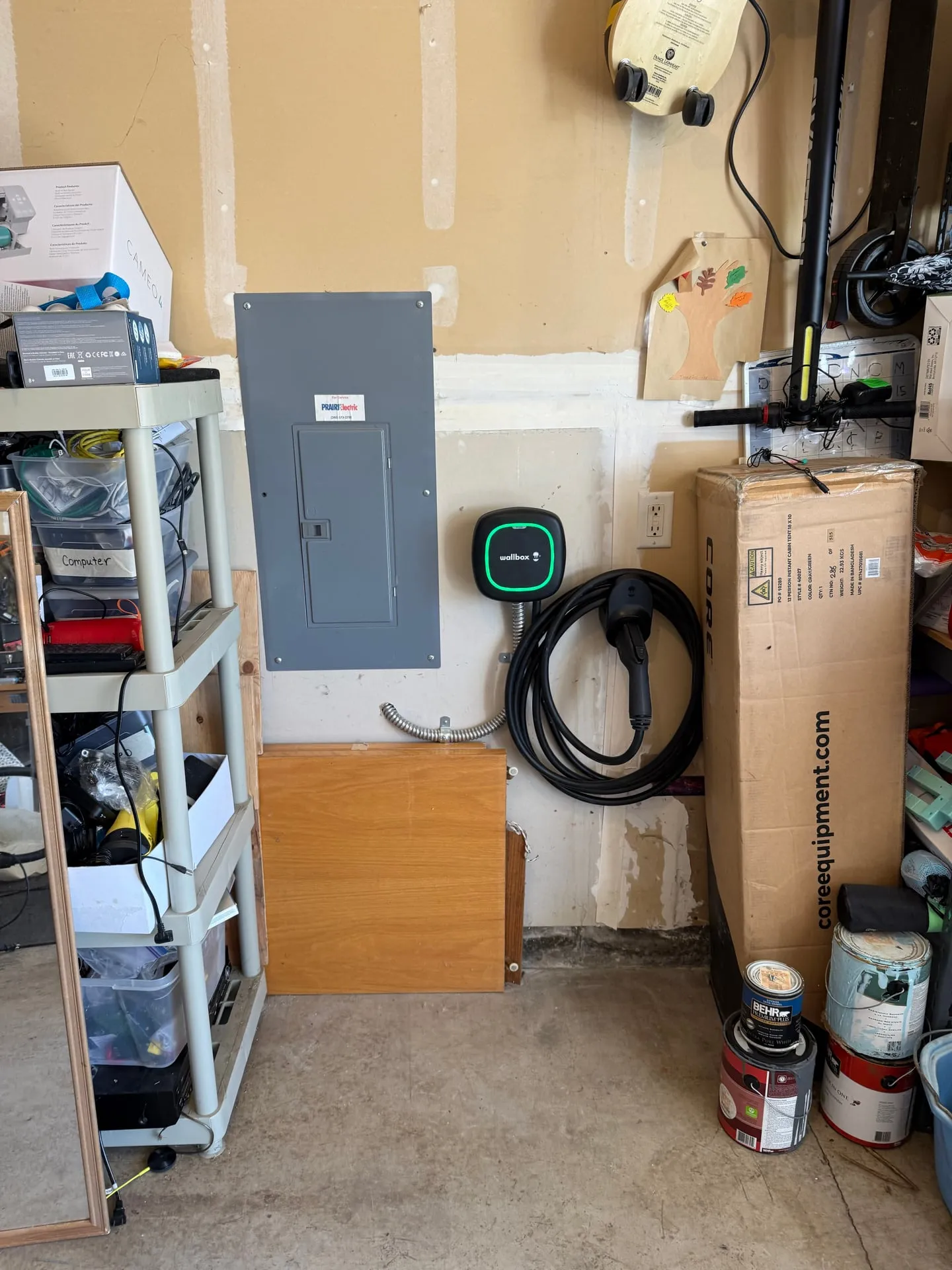 Wallbox Level 2 EV charger mounted on a garage wall next to the main panel in Fishers Landing, Vancouver WA, installed by Newman Electric with its J1772 cord hanging ready to charge