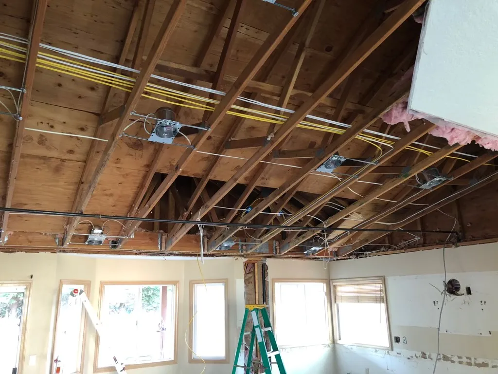 Exposed residential electrical wiring in open ceiling during rewiring project