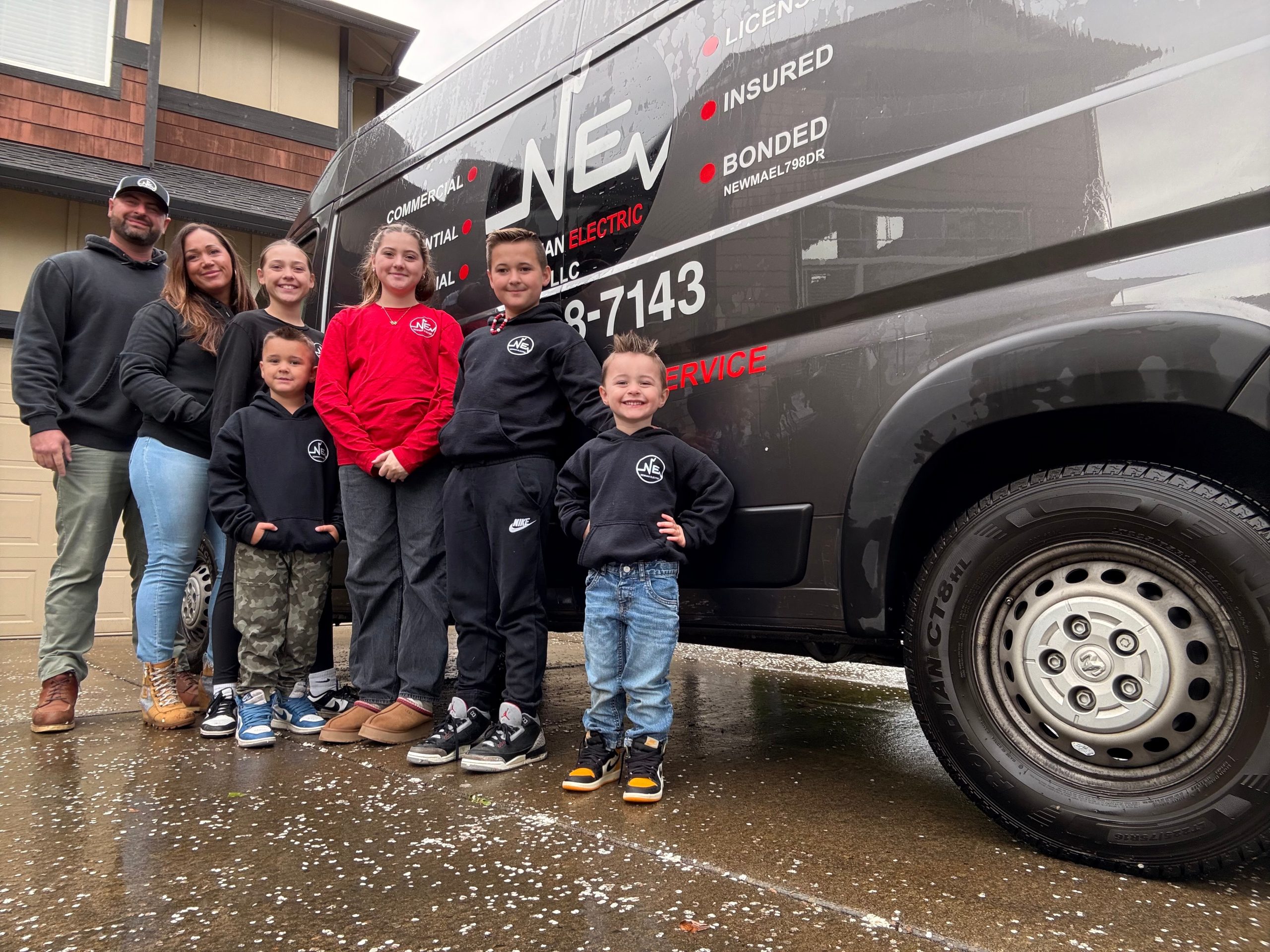 Ryan Newman and his family standing by the Newman Electric van